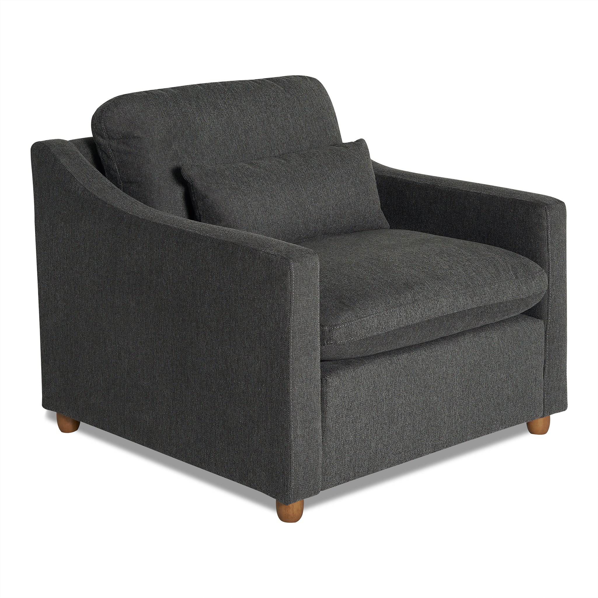 The My Cloud Slope Chair, with its dark gray modern design and wooden legs, epitomizes comfort and style. Featuring a plush build and matching lumbar cushion, its slightly curved armrests enhance the inviting appeal for a true My Cloud relaxation experience.