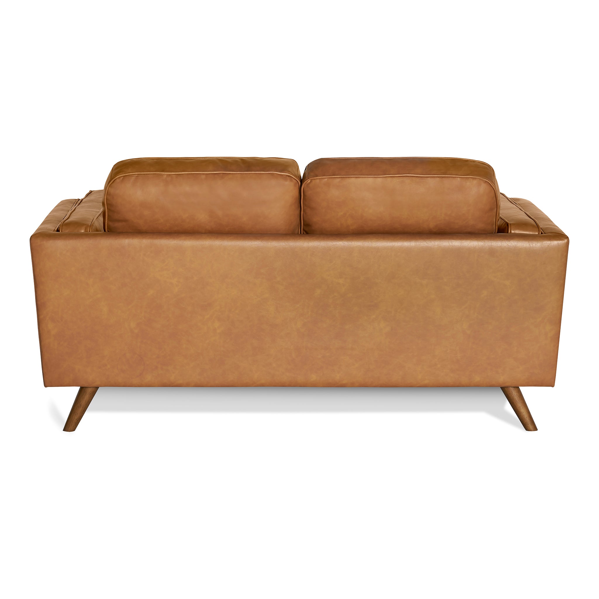 Back view of the Maddox Loveseat showcasing its mid-century modern design with tan leather upholstery. It features two large cushions and outward-angled wooden legs, set against a plain white background, highlighting its durable construction and retro charm.