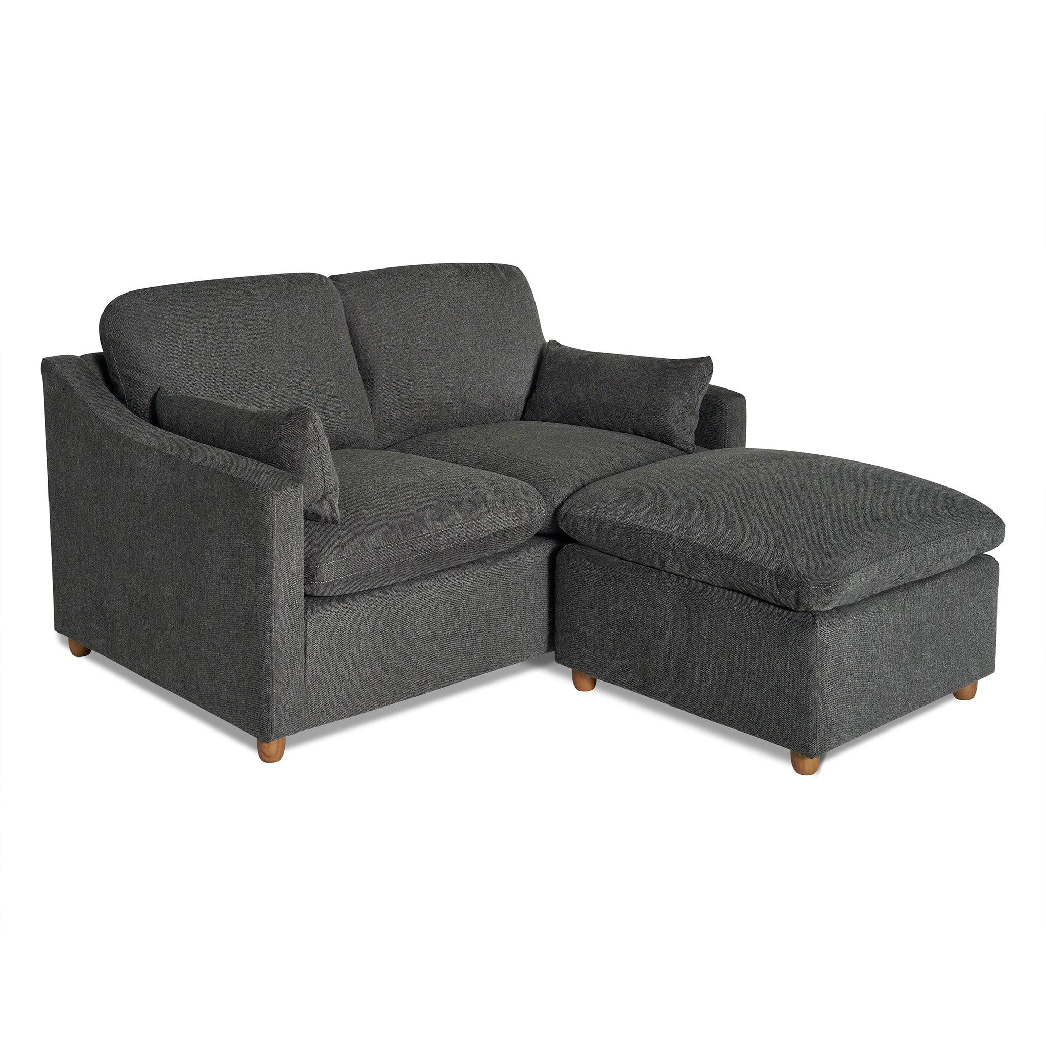 The My Cloud Slope Loveseat, in dark gray upholstery with square arms, features an accompanying matching ottoman on the right. Both pieces offer a plush look and stand on small wooden legs, combining style with durable furniture design.