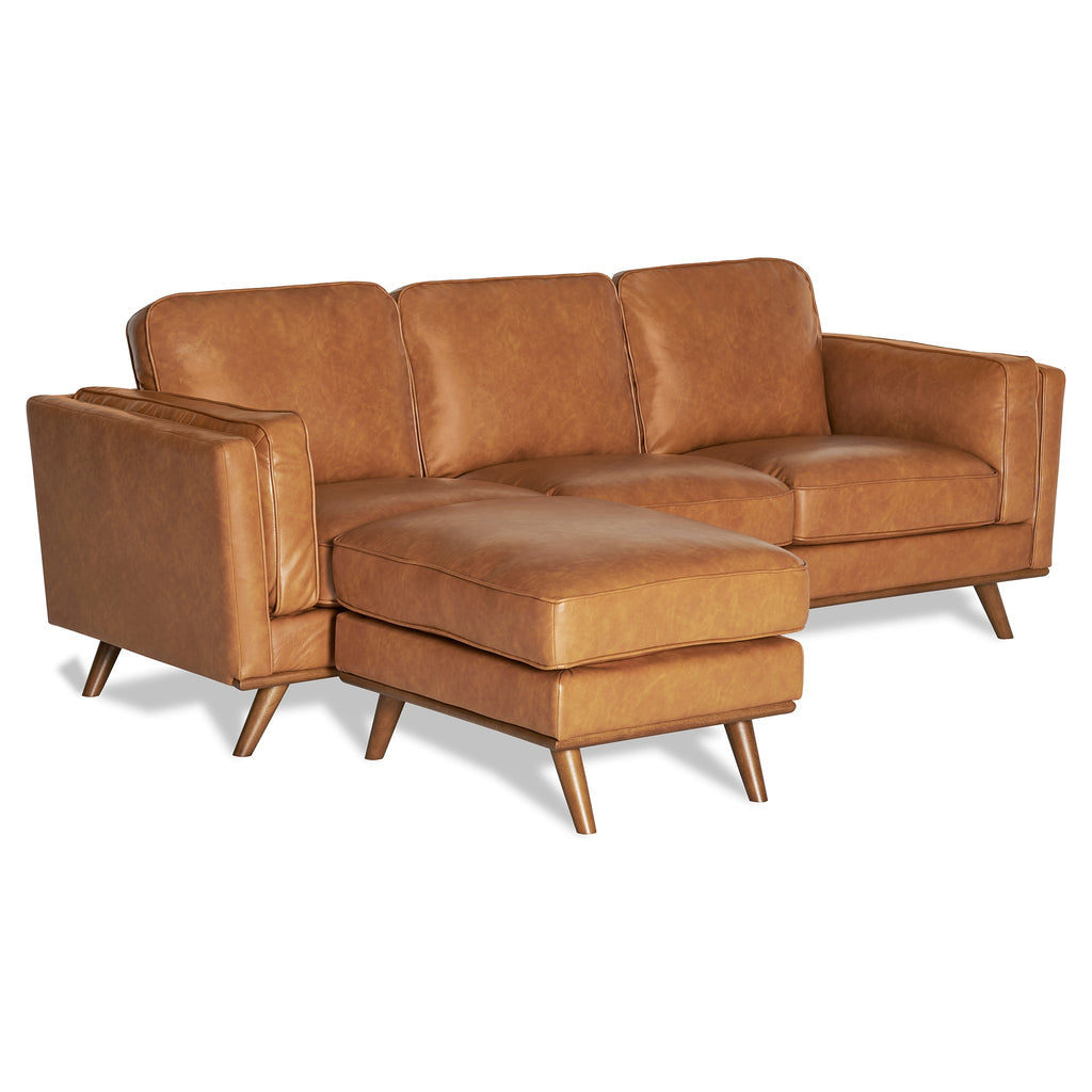 The Maddox Sofa is a brown leather sectional with plush cushions and a left-side chaise lounge. This mid-century modern design includes three cushioned backrests and wooden legs, set elegantly against a white background.