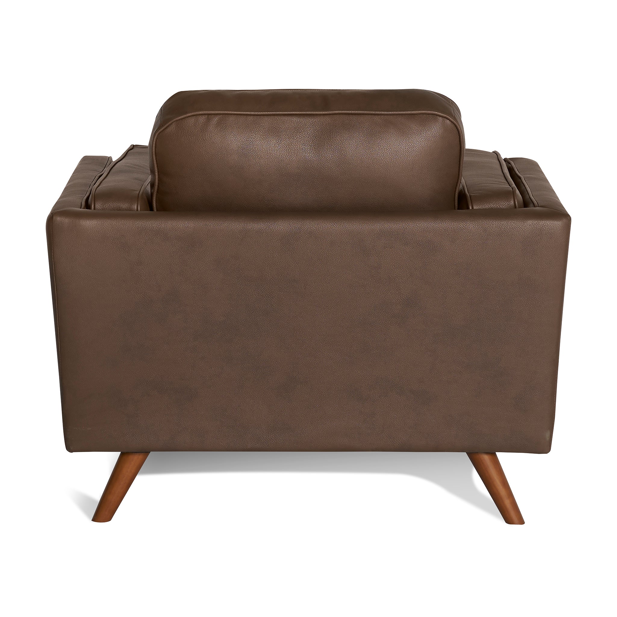 The back view of the Maddox Chair, a mid-century modern brown leather armchair, displays slightly angled wooden legs against a white background and features plush cushions on the backrest and armrests, reflecting its timeless design.
