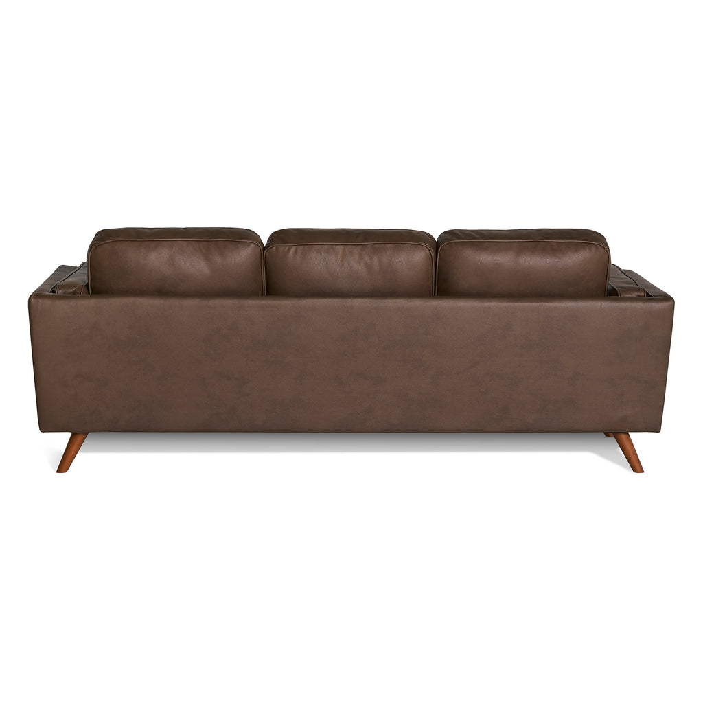 The Maddox Sofa features a back view of a brown leather design with three plush cushions and angled wooden legs, highlighting its mid-century modern style against a white background.