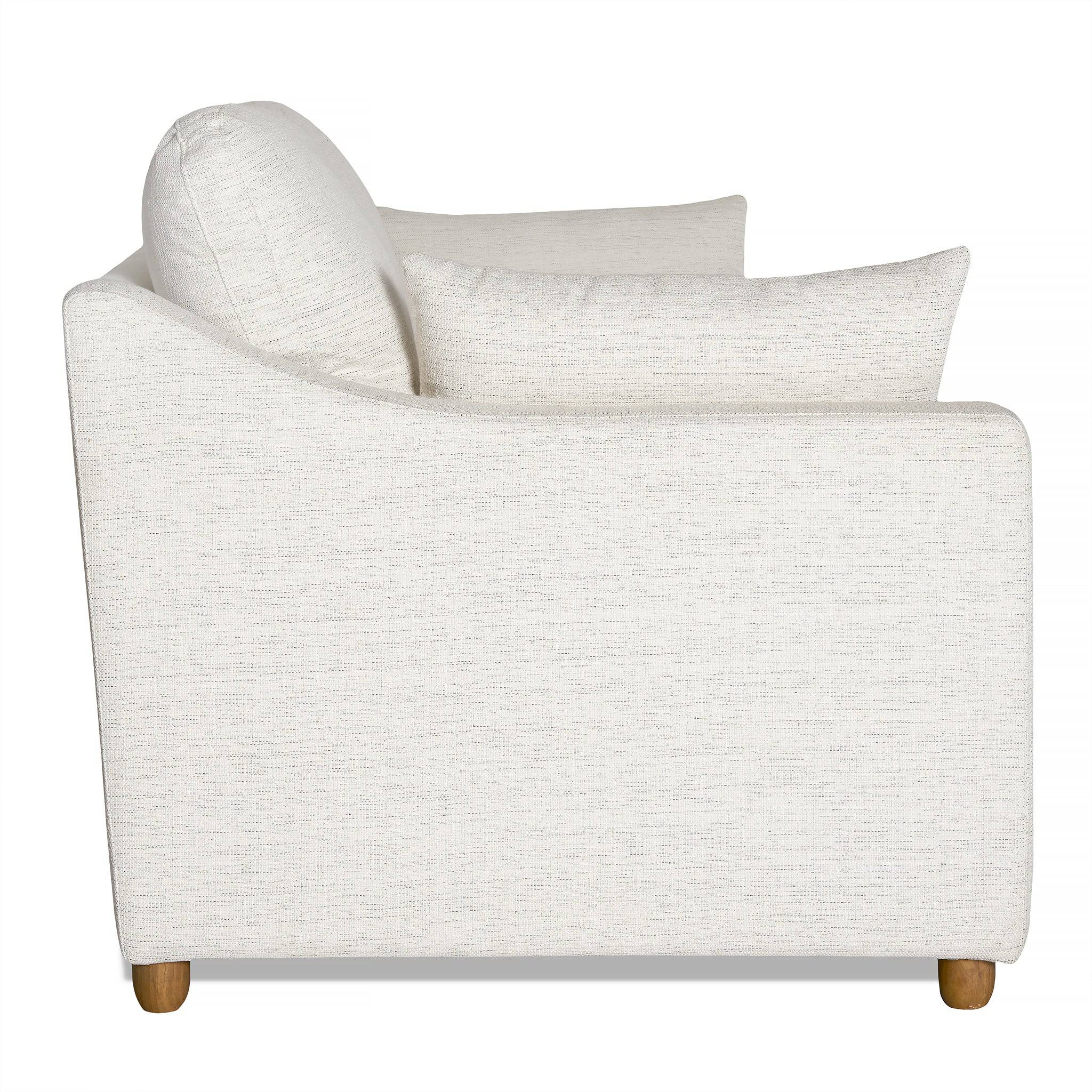 Side view of the My Cloud Slope Sofa, a white fabric piece with a pillow, wooden legs, and minimalist design. It features slightly curved armrests and subtle fabric texture. Machine-washable covers add convenience.