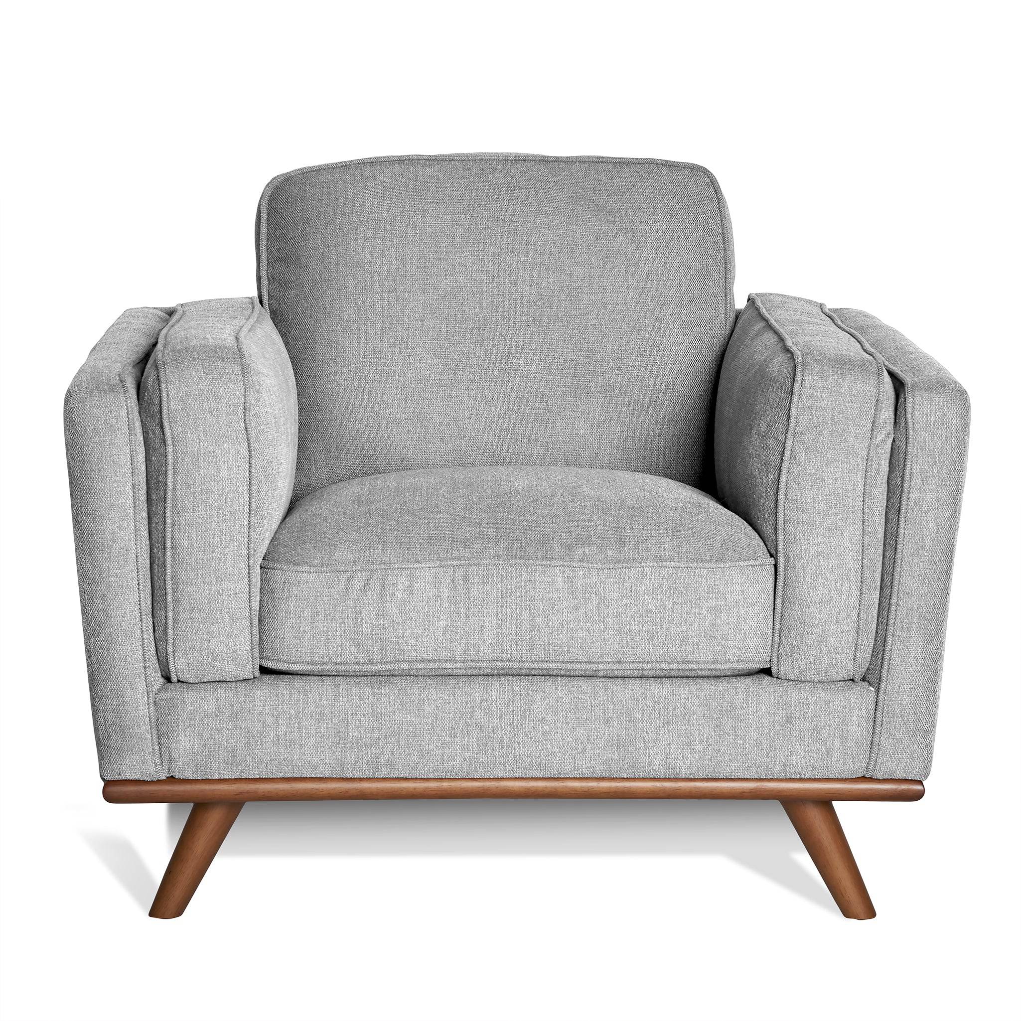 Discover the Maddox Chair, a mid-century modern masterpiece with a stylish boxy design. This gray armchair includes plush cushions, wooden legs, and thick armrests against a white backdrop for timeless appeal.