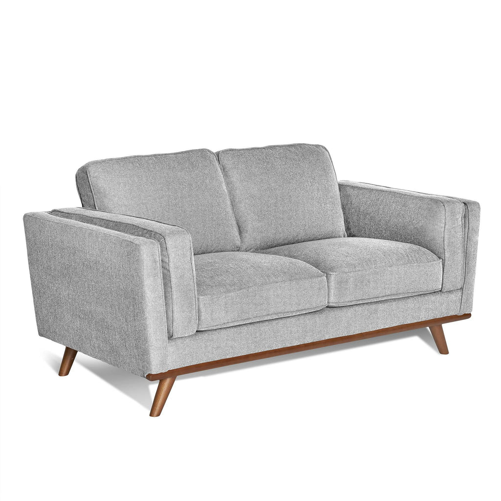The Maddox Loveseat features a mid-century modern design with plush cushions, soft gray upholstery, wide armrests, durable construction, and is highlighted by tapered wooden legs.