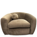 The Sculpture Swivel Chair is a large plush beige armchair with a rounded back and wide arms, featuring luxurious velvety-soft upholstery and a single round cushion on the seat for maximum comfort.