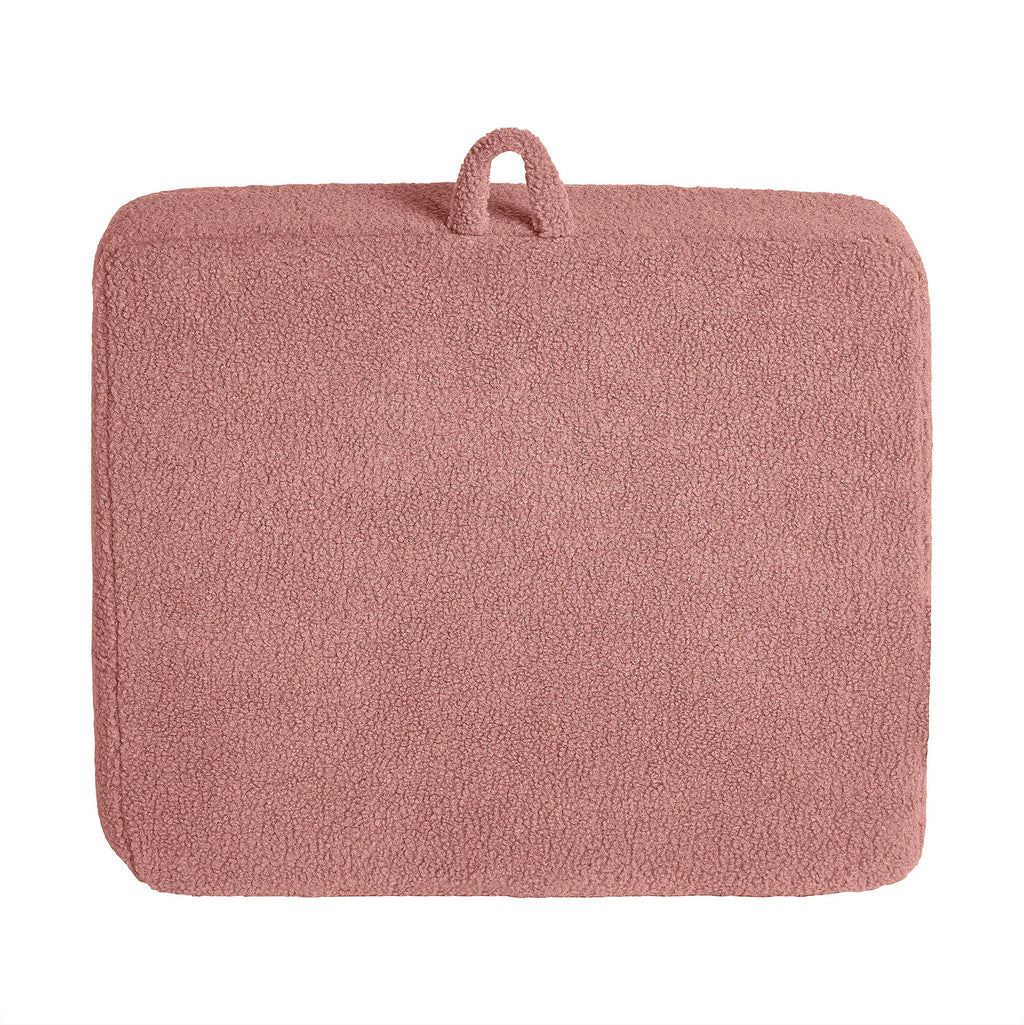 A soft pink rectangular bath mat with a plush Sherpa fabric surface and a small fabric loop enhances modern minimalism, pairing stylishly with the customizable My Cloud Kidz Chair.