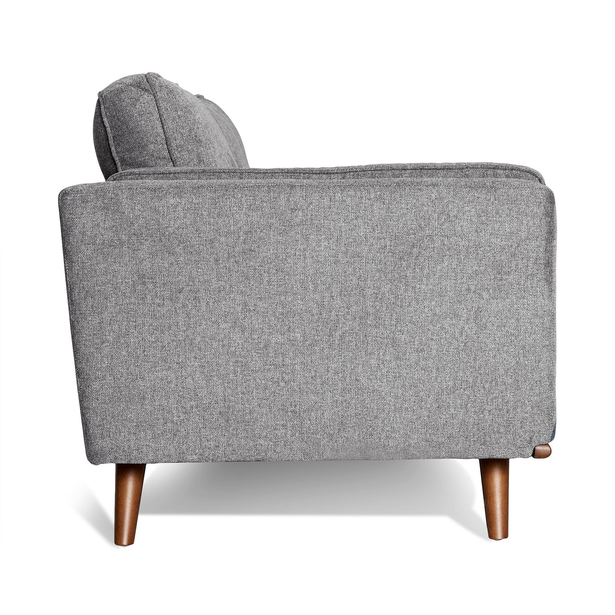 Side view of the Maddox Sofa, featuring gray upholstery and wooden legs in a mid-century modern style, set against a white background to emphasize its minimalist elegance.
